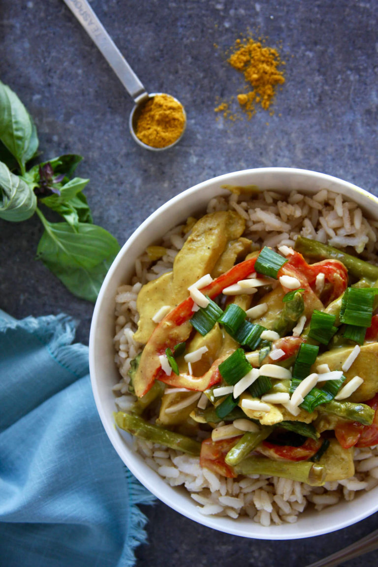 Overhead of a large bowl of curry and rice topped with green onions