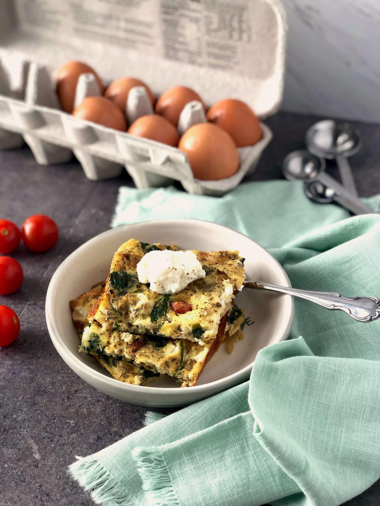 Frittata serving in a bowl in front of a carton of eggs