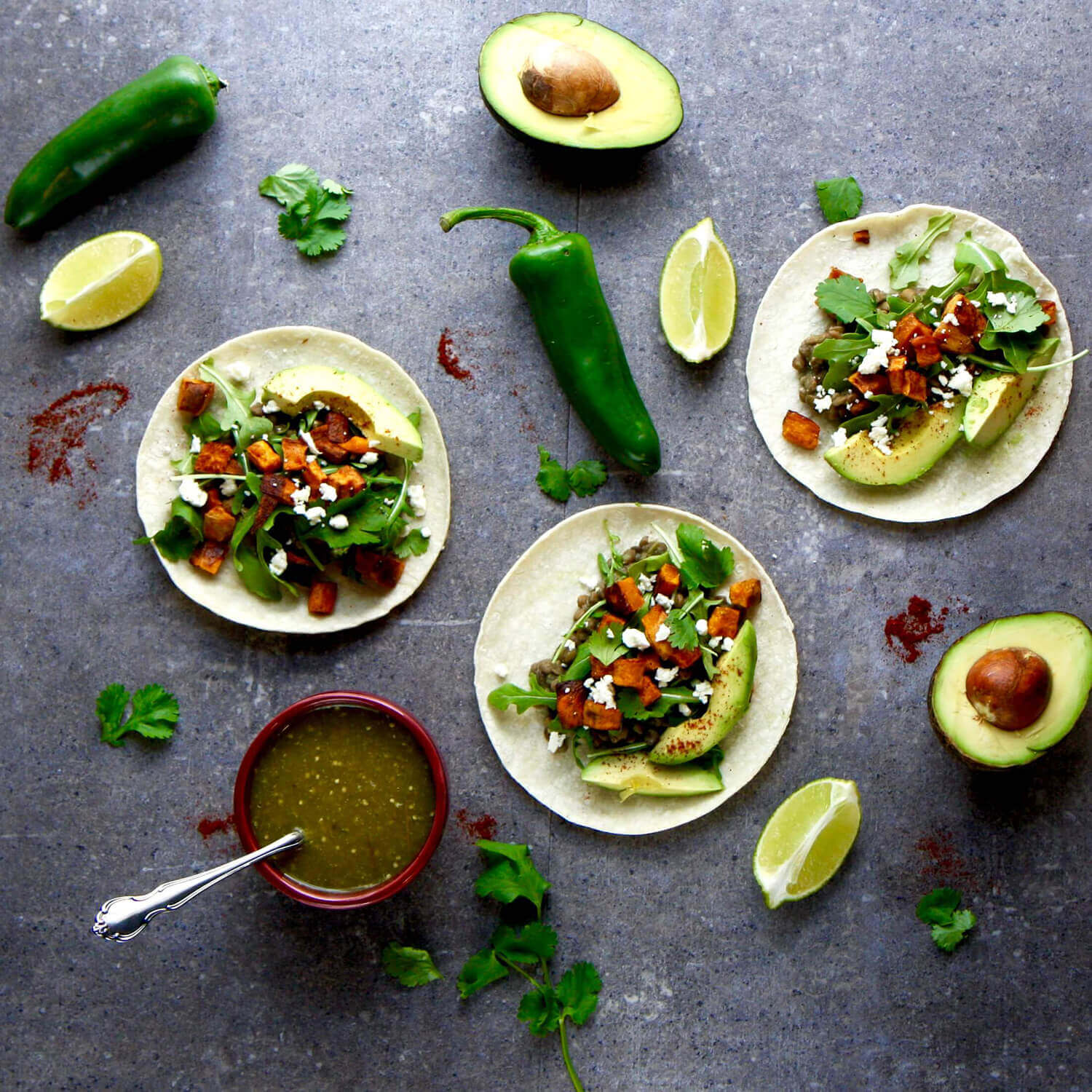 Overhead of tacos with various toppings on a dark background